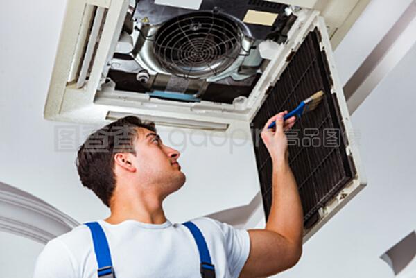 修理天花板空调设备的工人
